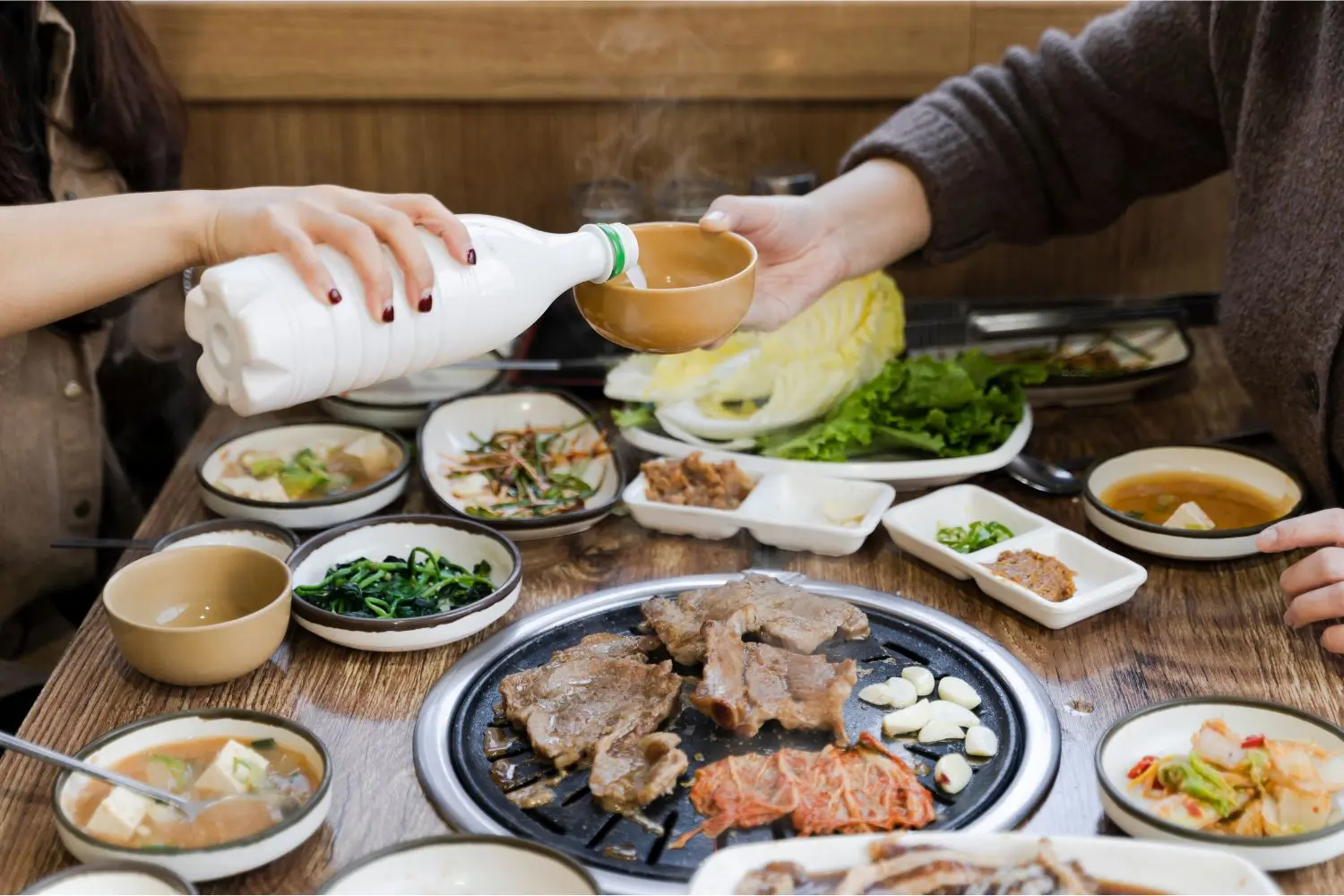 Korean BBQ grill set with assorted meats and sauces at Fire Pot Korean BBQ & Hot Pot, a Asian Restaurant in Grand Forks