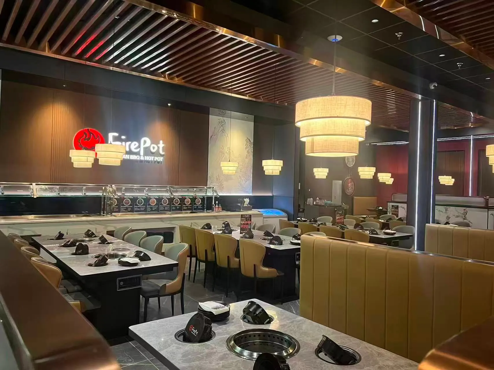 Spacious bright dining hall with booth seating and pendant lamps at FirePot Korean BBQ & Hot Pot, an Asian Restaurant in Grand Forks