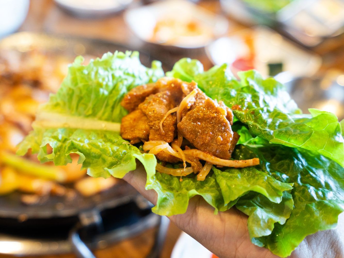Marinated pork wrapped in crisp lettuce with shredded radish at FirePot Korean BBQ & Hot Pot, an Asian Restaurant in Grand Forks