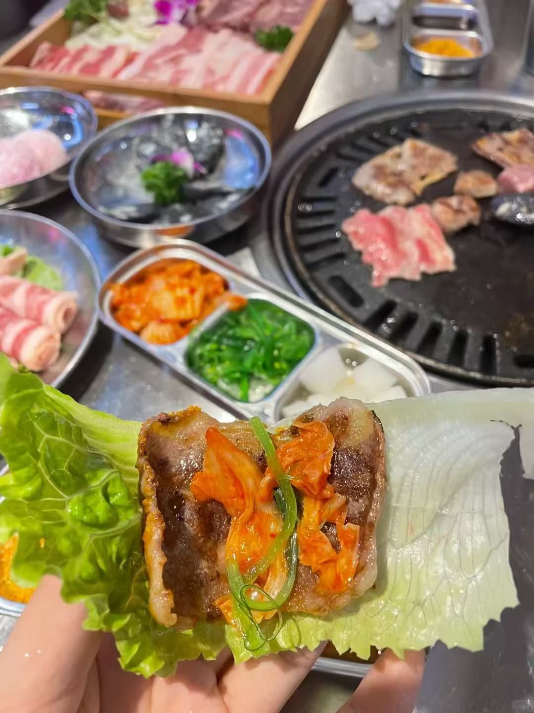 Grilled pork belly wrapped in lettuce with kimchi and green onion at FirePot Korean BBQ & Hot Pot, a Asian Restaurant in Grand Forks