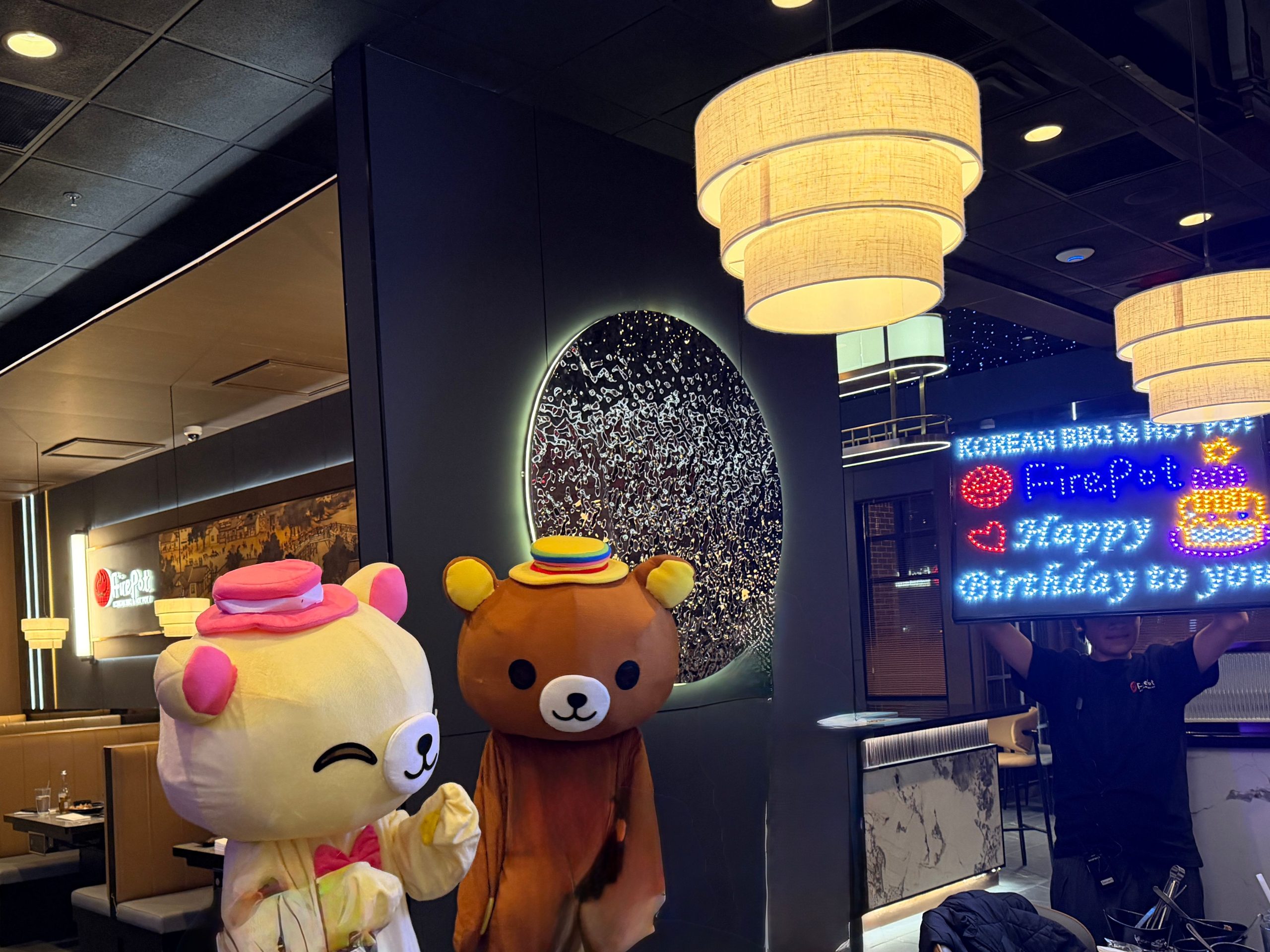 Two cute bear mascots pose inside the decorated restaurant interior at FirePot Korean BBQ & Hot Pot, an Asian Restaurant in Grand Forks